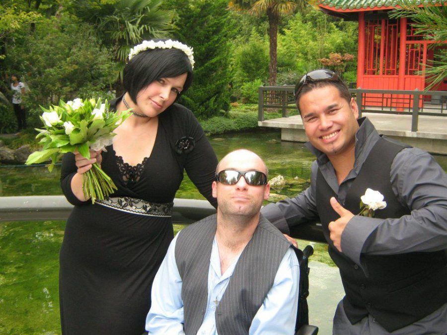 Gray with a newly married couple in a garden