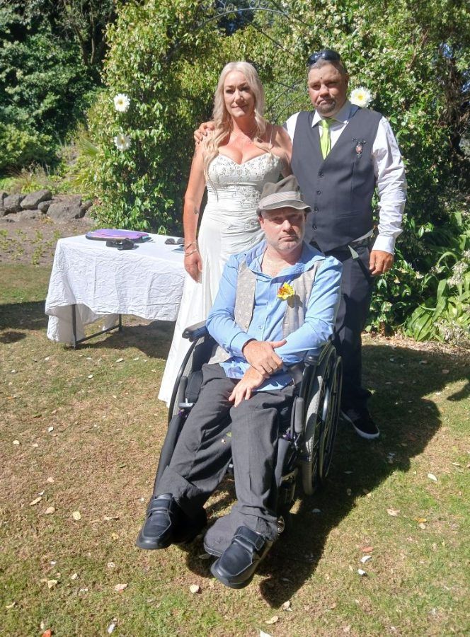 Gray with a couple on a lawn after their ceremony